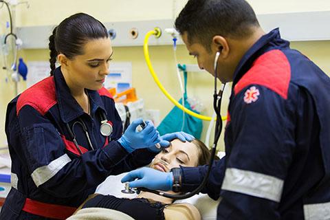 image of two emts looking at a patient